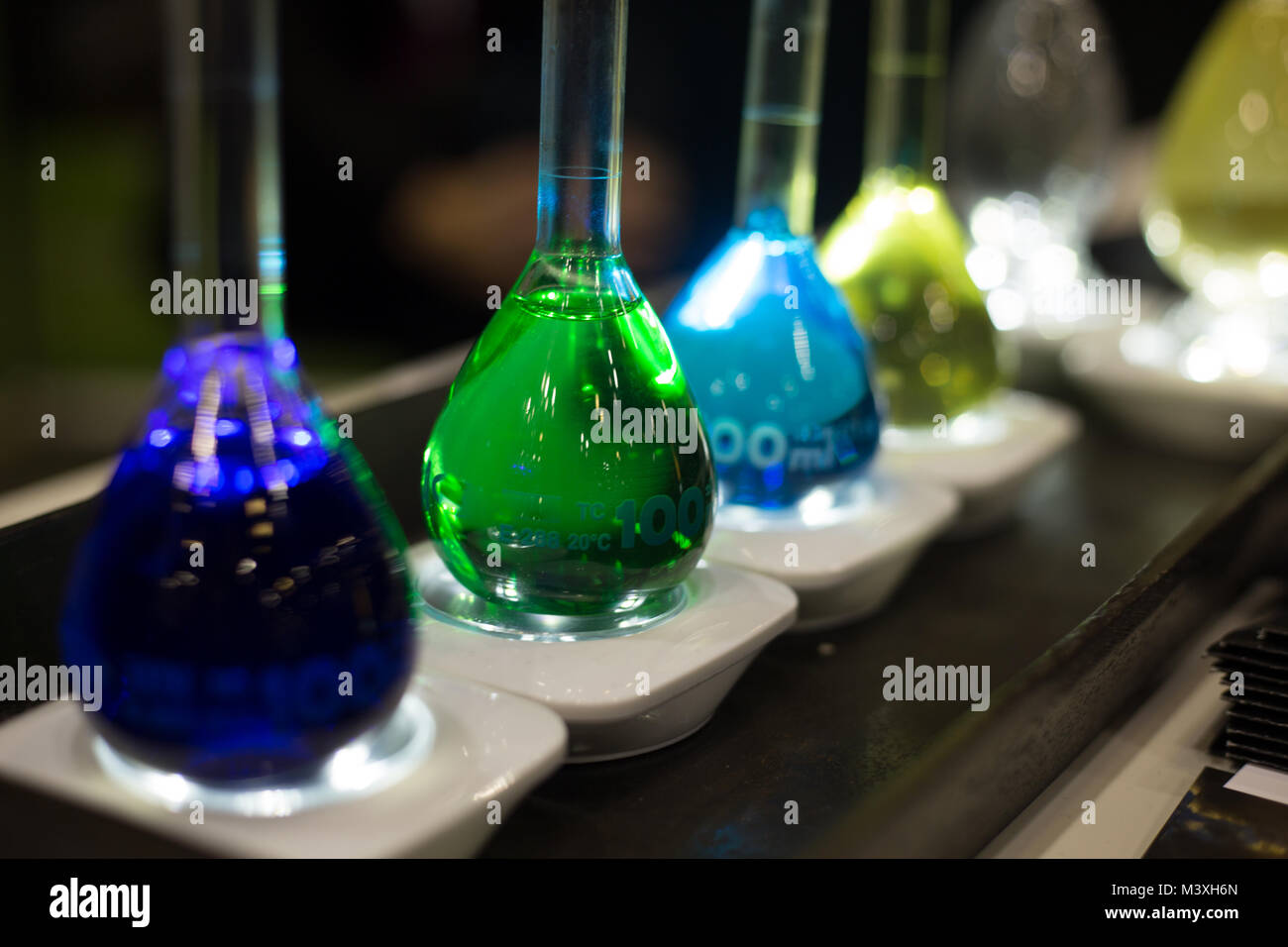 Concetto di test di laboratorio di chimica di vetro bottiglie sfondo scuro Foto Stock