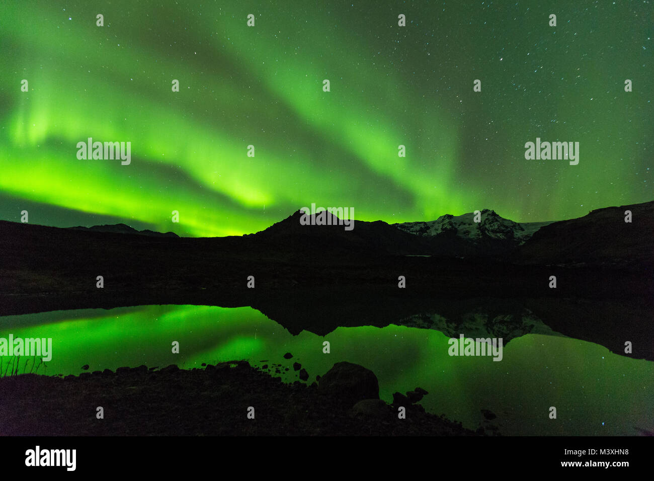 Green aurora luce dietro il lago di montagna in Islanda Europa al parco nazionale di skaftafell Foto Stock