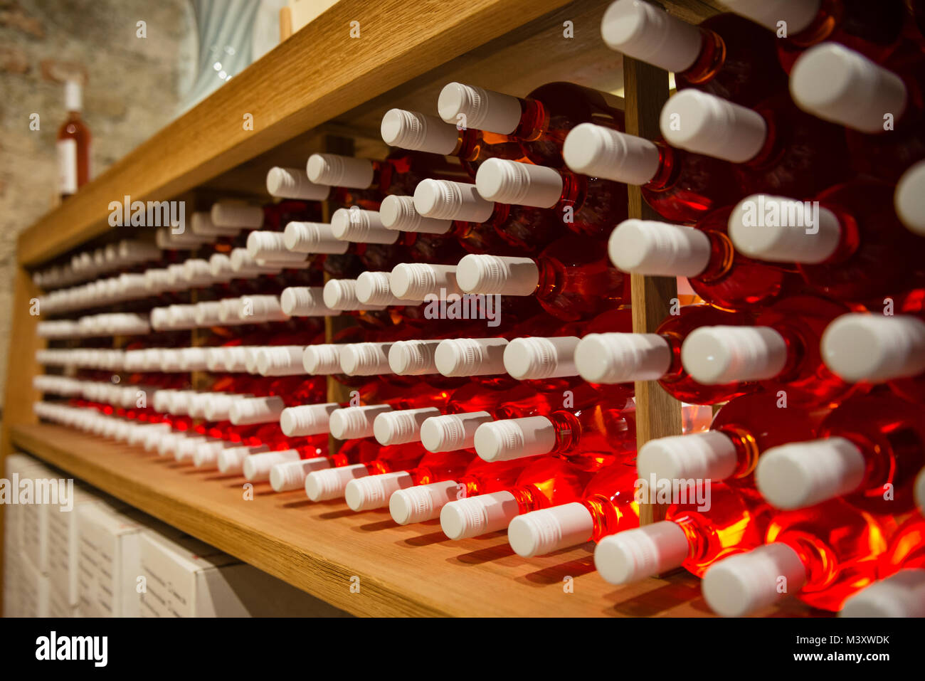 Bottiglie di vino rosa sul ripiano in cantina Foto Stock