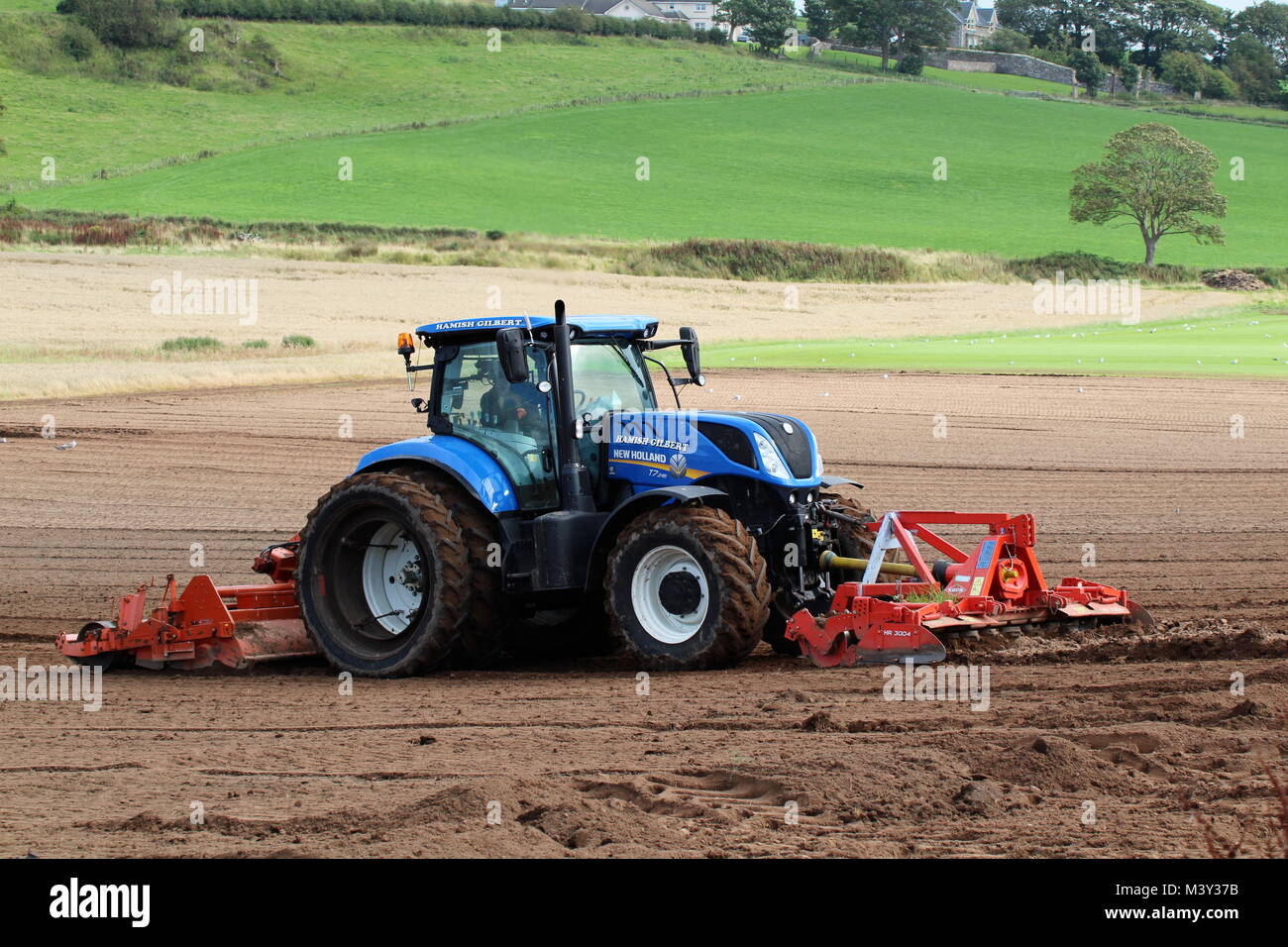 Un New Holland T7.245 trattore azionato da Hamish Gilbert, preparare il terreno a West Kilbride in Ayrshire. Foto Stock