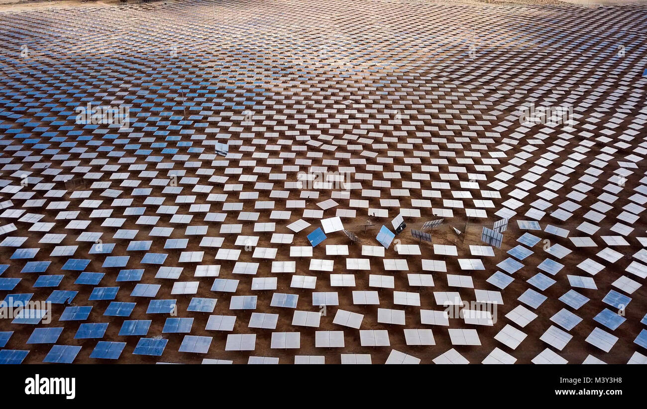 Centrale solare specchi che concentrano i raggi del sole su una torre di collettore per la produzione di energie rinnovabili, esente da inquinamento energia - immagine aerea Foto Stock