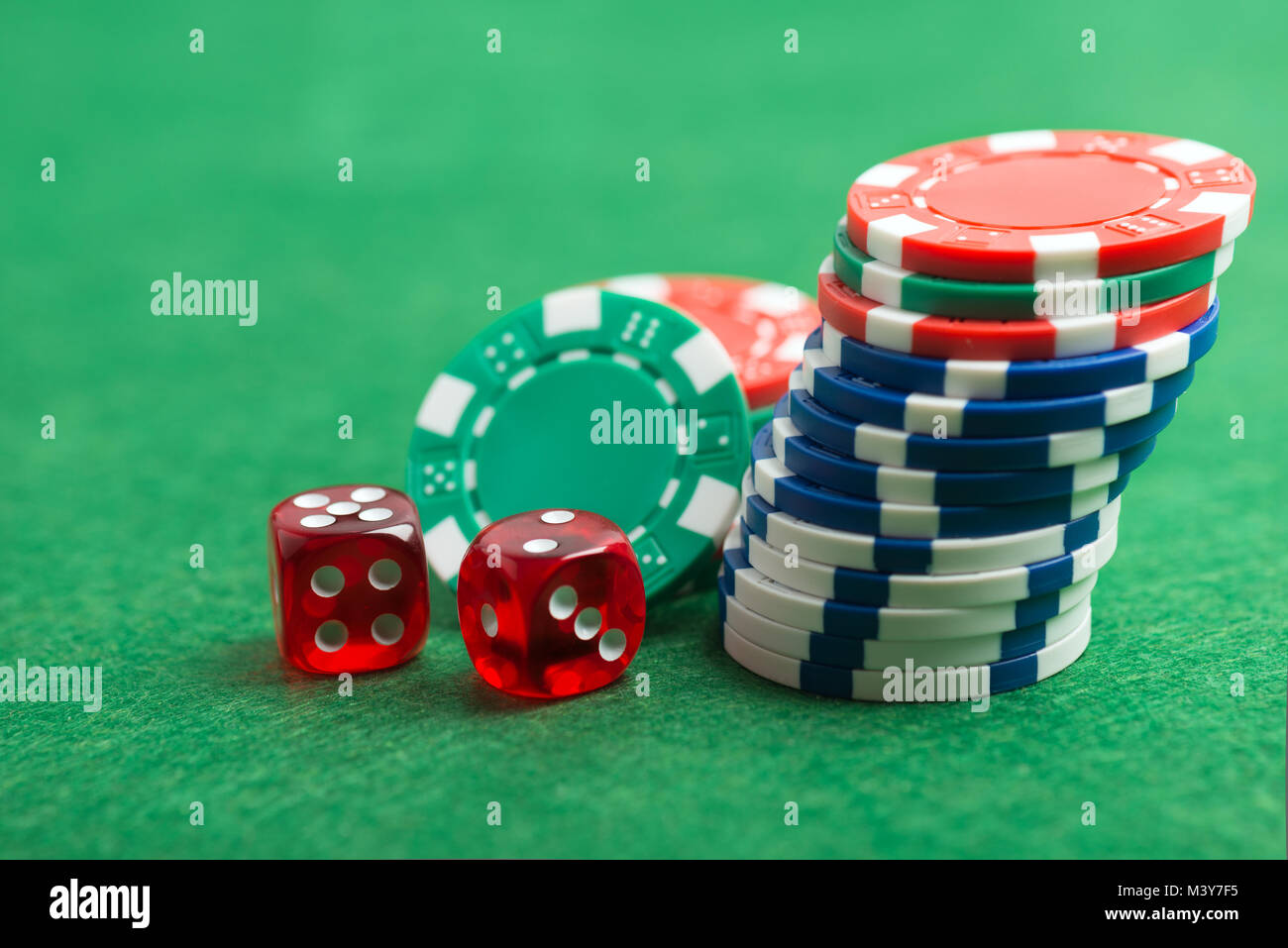 Casino chip e dadi su un feltro verde come sfondo Foto Stock