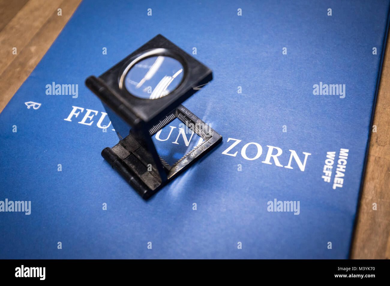 Attenzione: è sotto embargo PER LA PUBBLICAZIONE FINO AL 14 FEBBRAIO 00:00 GMT! - Un tester di biancheria sorge su una stampata di fresco e incollati copertina del libro 'Feuer und Zorn. Im Weissen Haus von Donald Trump', il tedesco della prima edizione di "Fire e furia. All'interno del Trump White House', cinghia durante un press tour presso il CPI Clausen & Bosse printing company in Lübeck, Germania, 09 febbraio 2018. Il libro di rivelazione da M. Wolff circa US-presidente americano sarà pubblicato da Rowohlt il 16 febbraio 2018.(ATTENZIONE I REDATTORI: è sotto embargo fino al 14 Febbraio 2018 · 12 AM) Foto: Christian Charisius/dpa Foto Stock