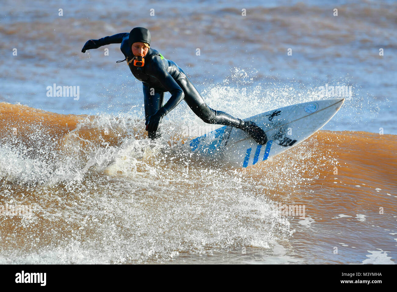 Sidmouth, Devon, Regno Unito. Il 13 febbraio 2018. Regno Unito Meteo. Un surfista godendo le buone condizioni delle onde sotto il sole a Sidmouth nel Devon dopo un burrascoso inizio di giornata. Credito Foto: Graham Hunt/Alamy Live News. Foto Stock