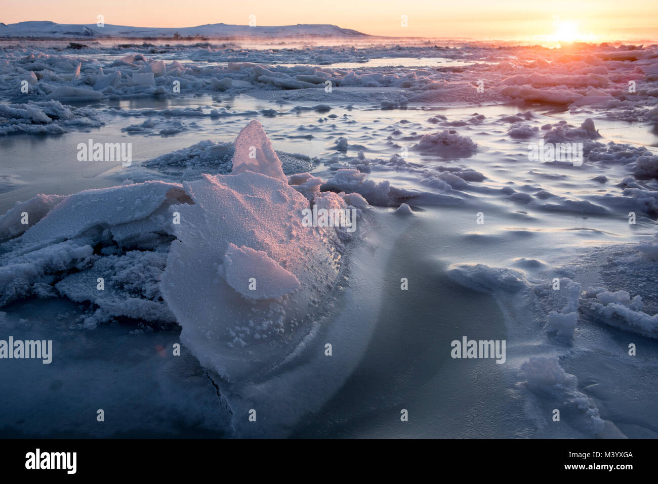 Coperti di ghiaccio litted mare da Rising Sun in Chukotka, regioni artiche della Russia Foto Stock