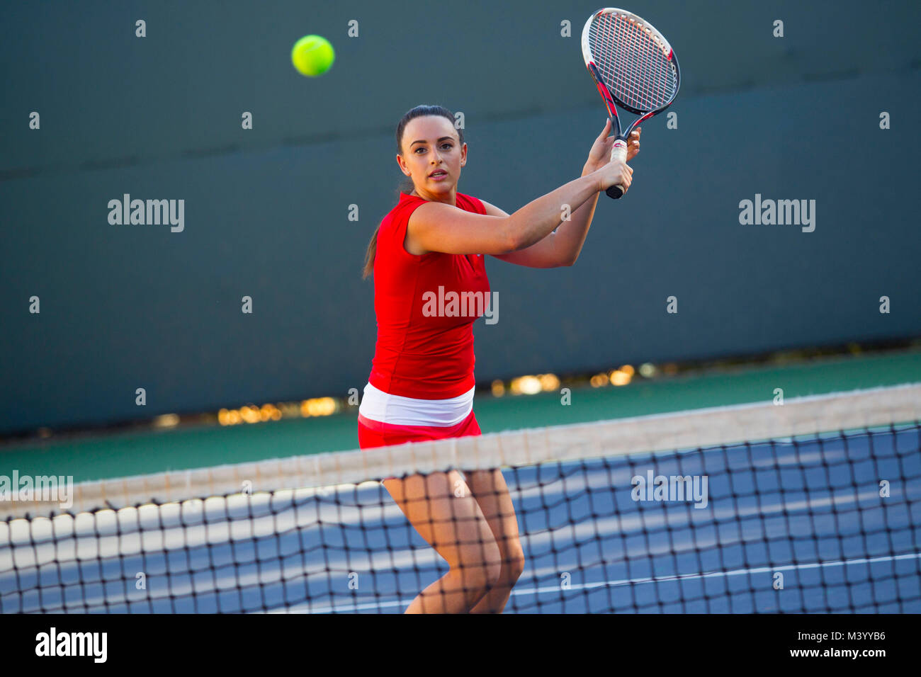 Un giovane giocatore di tennis colpisce un volley con la sua racchetta al netto su un campo da tennis in Beverly Hills, la California. Foto di Francesco Specker Foto Stock