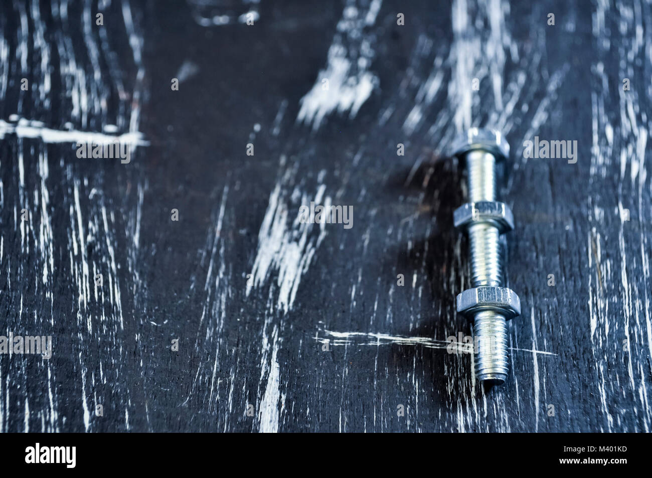 Dadi per le riparazioni che giace su di un tavolo di legno. I dadi di ferro e viti f Foto Stock