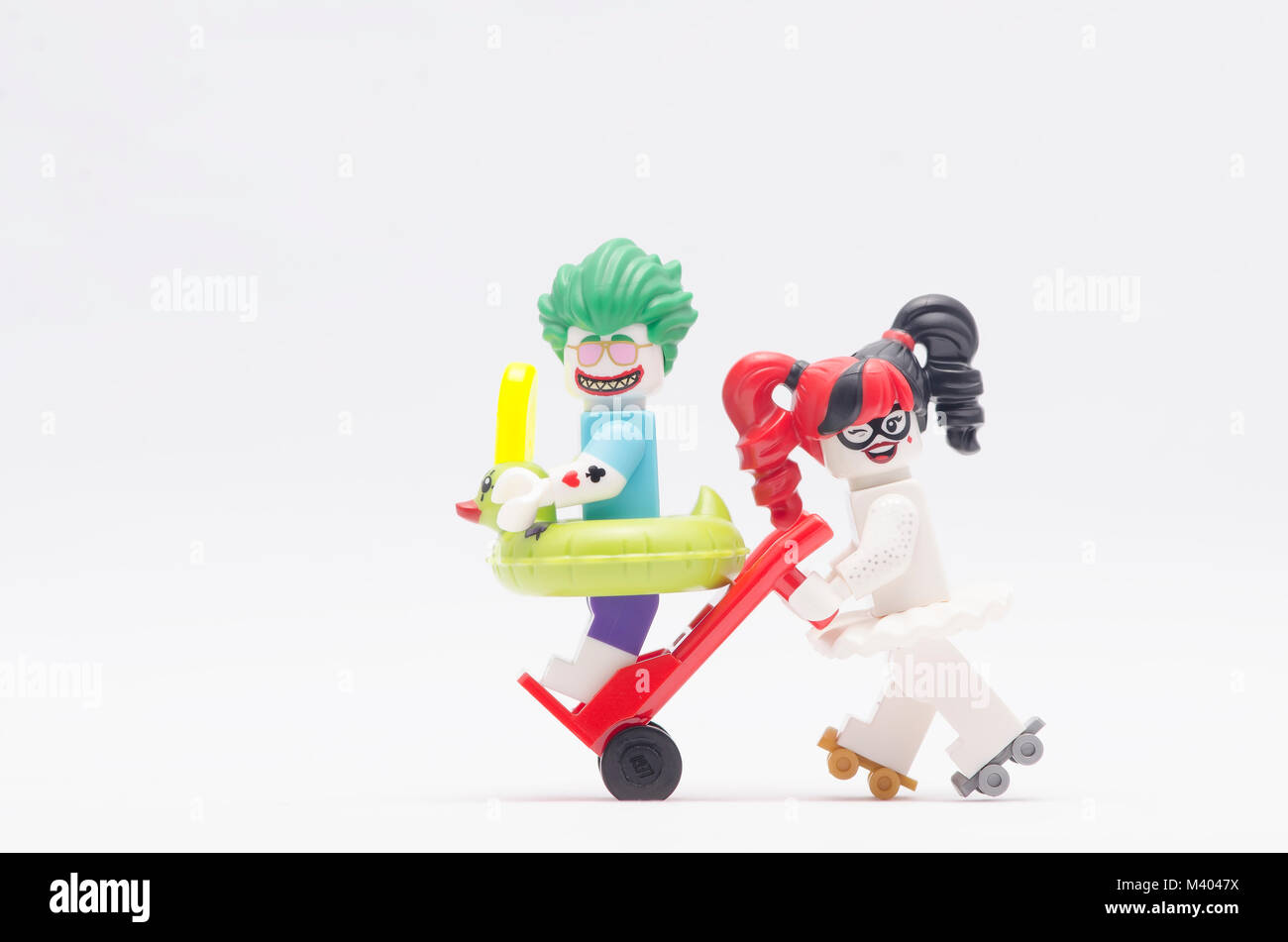 Lego Harley Quinn carrello di spinta con joker seduta su di esso. isolato su sfondo bianco. Foto Stock