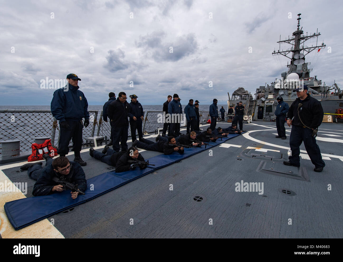 180206-N-RG482-016 MARE ADRIATICO (feb. 6, 2018) da bombardieri mate 1. Classe Gregorio Bissett, estrema destra, conduce un'arma sicurezza e familiarizzazione della formazione durante una piccola pistola armi sparare a bordo del Arleigh Burke-class guidato-missile destroyer USS Ross (DDG 71). Ross, distribuita a Rota, Spagna, è sulla sua sesta patrol NEGLI STATI UNITI Sesta flotta area di operazioni a sostegno degli enti regionali alleati e partner negli Stati Uniti e gli interessi di sicurezza nazionali in Europa. (U.S. Foto di Marina di Massa lo specialista di comunicazione 1a classe Kyle Steckler/rilasciato) Foto Stock