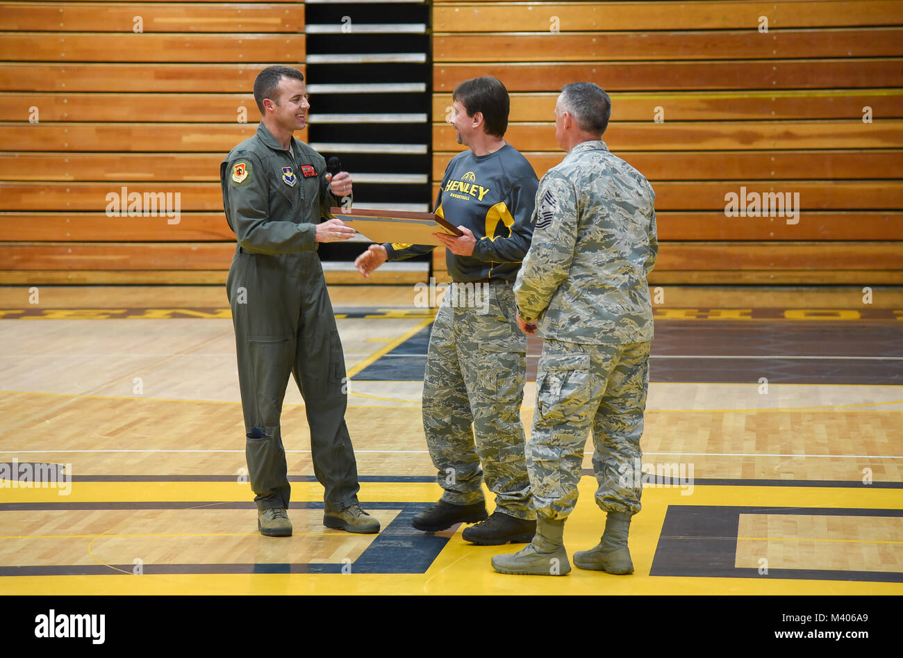 Stati Uniti Air Force Col. Jeff Edwards, il 173rd Fighter Wing vice comandante, presenta una foto di una 173rd FW F-15 Eagle a Jack Lee, Henley alta scuola principale, durante un militare di apprezzamento della notte, 6 febbraio 2018, in Klamath Falls, Ore. il 173rd Fighter Wing ha supportato l'evento con schermi da parte delle forze di sicurezza squadron, del controllo del traffico aereo squadron, il gruppo manutenzione, equipaggi apparecchiature di volo e il negozio di armi per gli studenti e i membri del pubblico per visualizzare prima e durante il gioco. (U.S. Air National Guard photo by Staff Sgt. Riley Johnson) Foto Stock