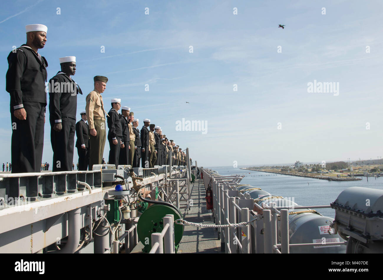 MAYPORT, Fla. (feb. 7, 2018) Marinai e Marines uomo le rotaie sul ponte di volo dell'assalto anfibio nave USS Iwo Jima (LHD 7) come esso si discosta Naval Station Mayport per una distribuzione a sostegno di le operazioni di sicurezza marittima e di teatro di sicurezza gli sforzi di cooperazione in Europa e il Medio Oriente. L'Iwo Jima Amphibious Ready Group si imbarca il ventiseiesimo Marine Expeditionary Unit e include Iwo Jima, il trasporto anfibio dock nave USS New York (LPD 21), il dock landing ship USS Oak Hill (LSD 51), Fleet team chirurgico 8, elicotteri Sea Combat Squadron 28, Tactical Air Control Squadron 22, Foto Stock