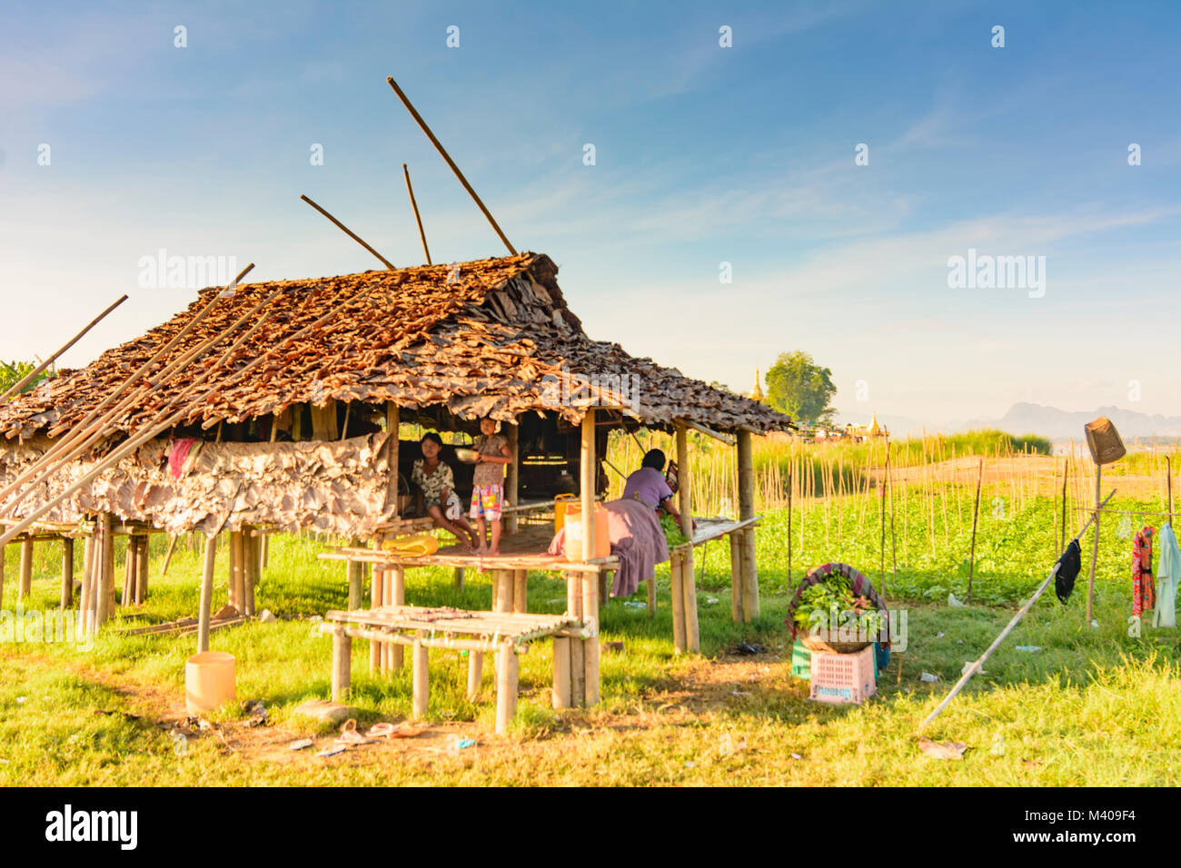 Hpa-An: farm house di bambù e asciugare banana-leaf sterpaglia, ragazza ragazze, campo , Kayin (Karen) Stato, Myanmar (Birmania) Foto Stock