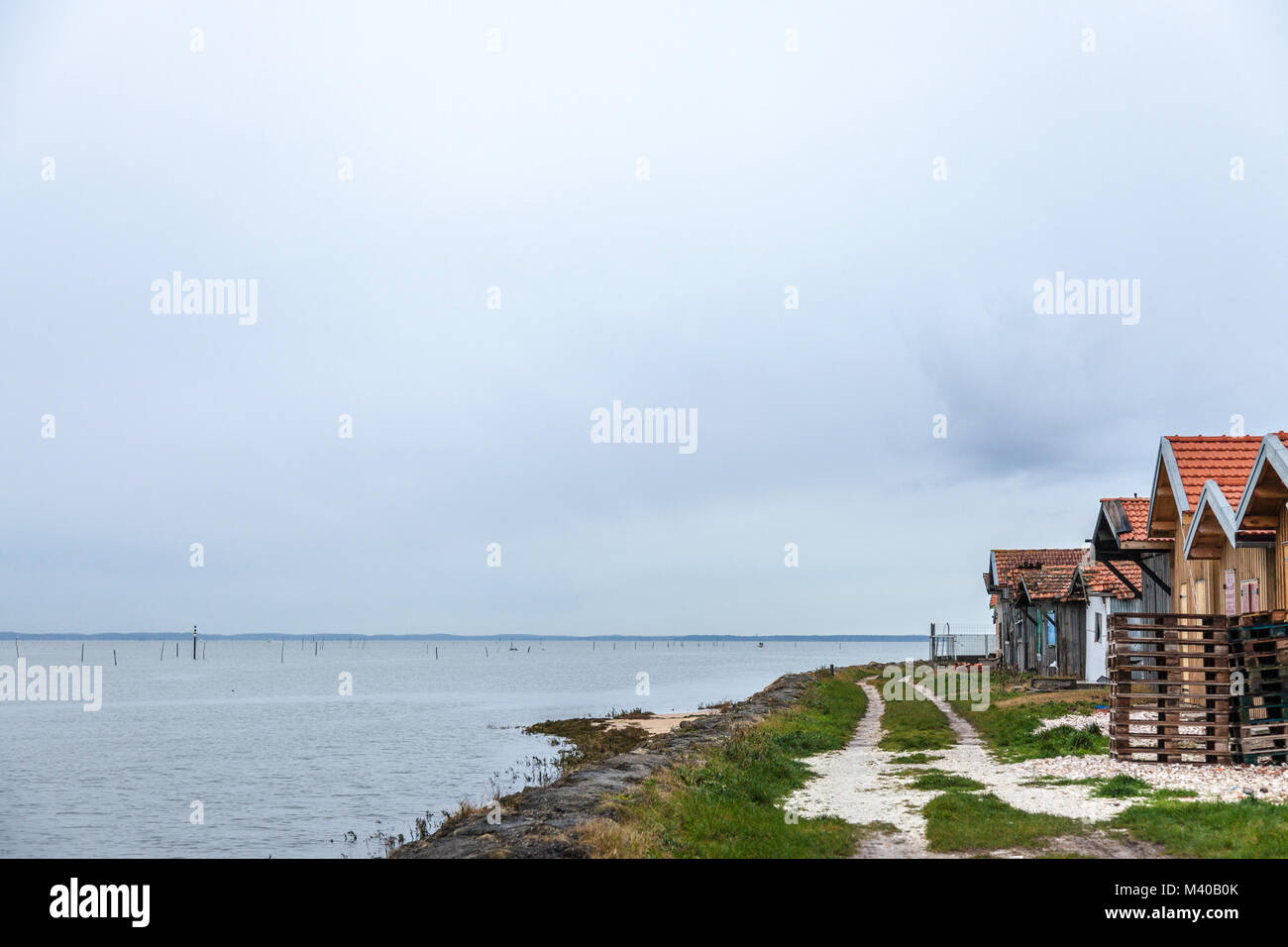 Gli allevatori di ostriche di capanne vicino all'Oceano Atlantico durante un nuvoloso pomeriggio piovoso sulla baia di Arachon (Bassin d'Arcachon) nella parte sud-ovest della Francia, in Aquitaine. Un Foto Stock