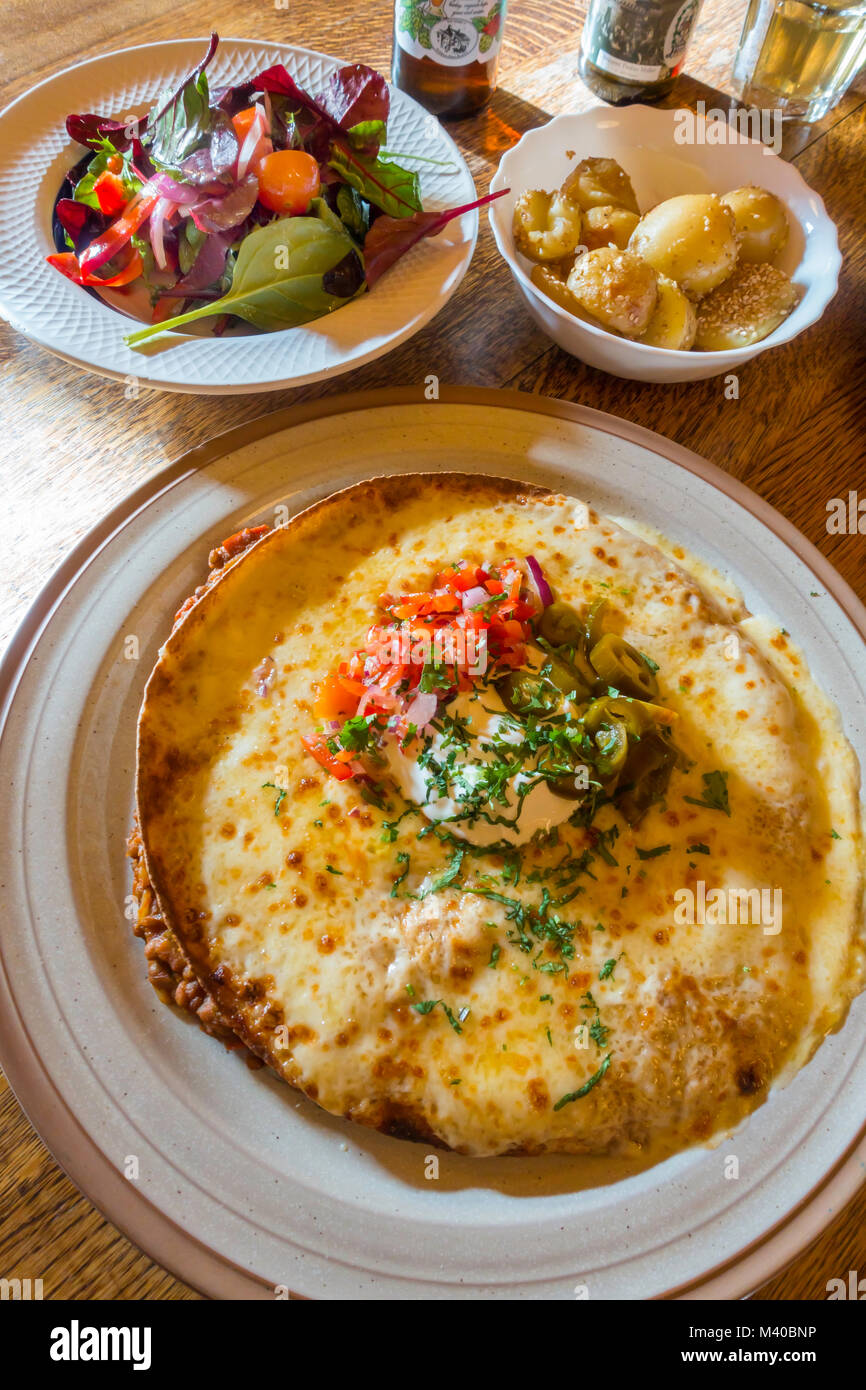 Vegetarian Enchilada Puy lenticchie in tortilla con formaggio fuso di panna acida salsa e jalapeños insalata di rucola e patate di sesamo Foto Stock