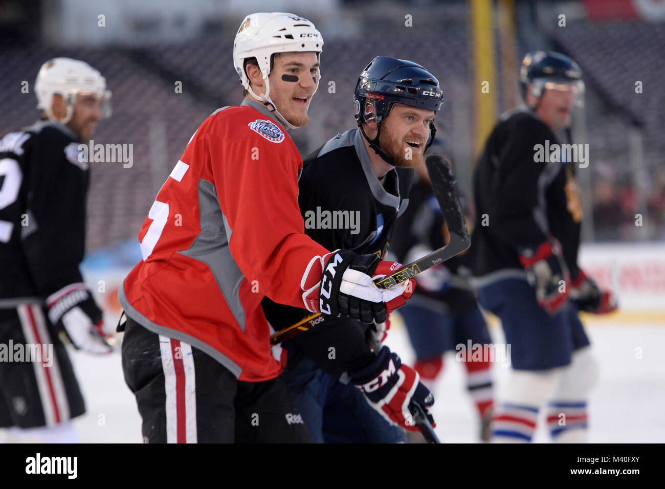 Chicago Blackhawks center Andrew Shaw, sinistra e Jeremy Mishler degli STATI UNITI D'AMERICA Guerrieri veterani feriti squadra di hockey di reagire alla verifica di ogni altro durante una giornata media gioco per il Classico inverno 2015 a Washington D.C. Dic. 31, 2014. Le due squadre hanno giocato il ritiro squadra di hockey di stile per circa quindici minuti sul ghiaccio all'aperto a cittadini Stadium. (DoD News foto da EJ Hersom) 141231-D-DB155-005 dal DoD Notizie Foto Foto Stock