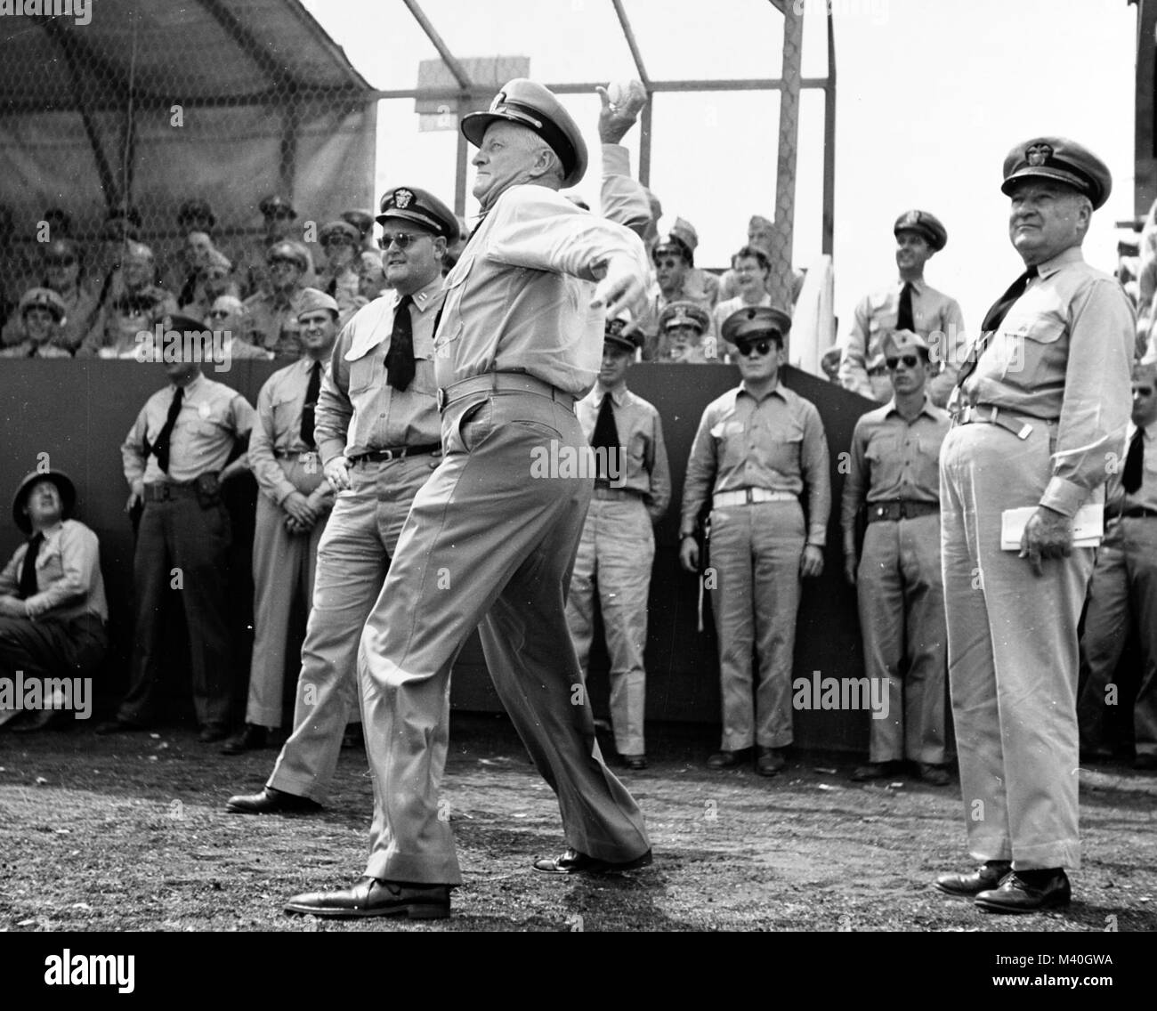 ADM Chester Nimitz (CINCPAC-POA) butta fuori la prima sfera in una mostra di baseball gioco in sede CINCPAC, Oahu, Hawaii, nel 1942. RADM William R. Furlong sta dietro l'ammiraglio per guardare il tiro. NH 58154 dal curatore di fotografia Foto Stock