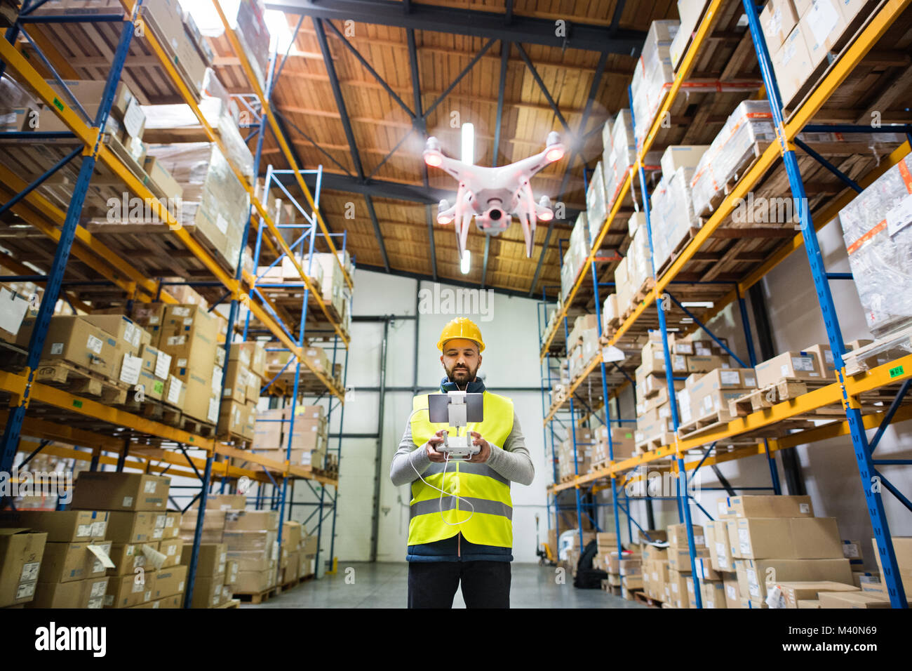 Uomo con drone in un magazzino. Foto Stock