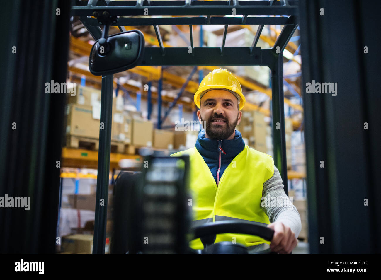 Magazziniere lavoratore con un carrello elevatore. Foto Stock