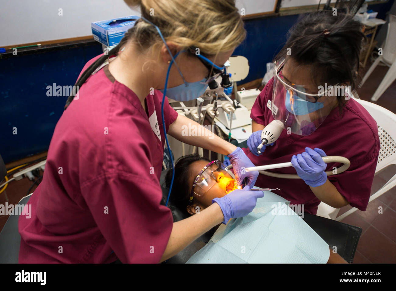 150620-N-XQ474-175 ACAJUTLA, El Salvador (20 giugno 2015) Lt. Lia Lorkovich, nativo di Aliquippa, Pa., e dentista assegnato all'Ospedale Navale di Beaufort, S.C. e un assistente dentale con le organizzazioni non governative (ONG) presso la University of California di San Diego Società Pre-Dental (UCSD PDS) eseguire una procedura dentale in un sito medico stabilito presso il Centro Escolar medico Eduardo Enrique Barrientos durante continuando promessa 2015 (CP-15). UCSD PDS volontari stanno lavorando al fianco di altre ONG e giunto il personale militare durante il CP-15. Continuando la promessa è un U.S. Comando sud-sponsorizzato e brevetto statunitense n. Foto Stock