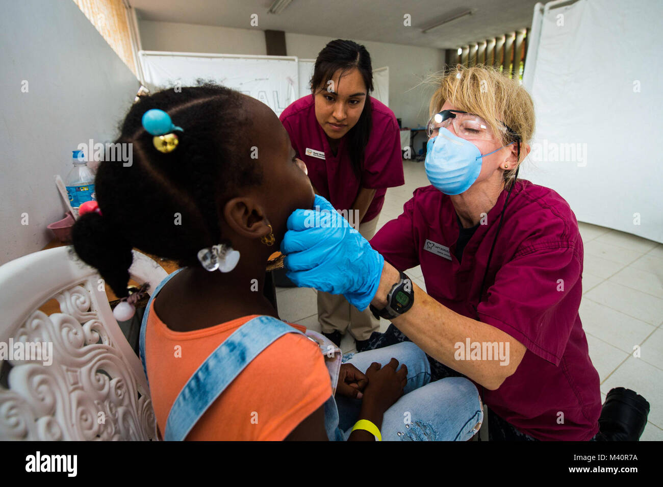 150710-N-NK JUANCHACO134-059, Colombia (10 luglio 2015) - Capt. Wendy Boruszewski, nativo di San Diego, California, e dentista assegnato a al Centro Medico Navale di Portsmouth, Va., destra e un volontario odontotecnico con le organizzazioni non governative (ONG) presso la University of California di San Diego Società Pre-Dental (UCSD-PDS), eseguire un esame dentale su un paziente in corrispondenza di un sito medico stabilito a Himno istituzione educativa Juanchaco durante continuando promessa 2015 (CP-15). UCSD-PDS volontari stanno lavorando a fianco di altre ONG e militari durante il CP-15. Continuando la promessa è un U.S. C meridionale Foto Stock