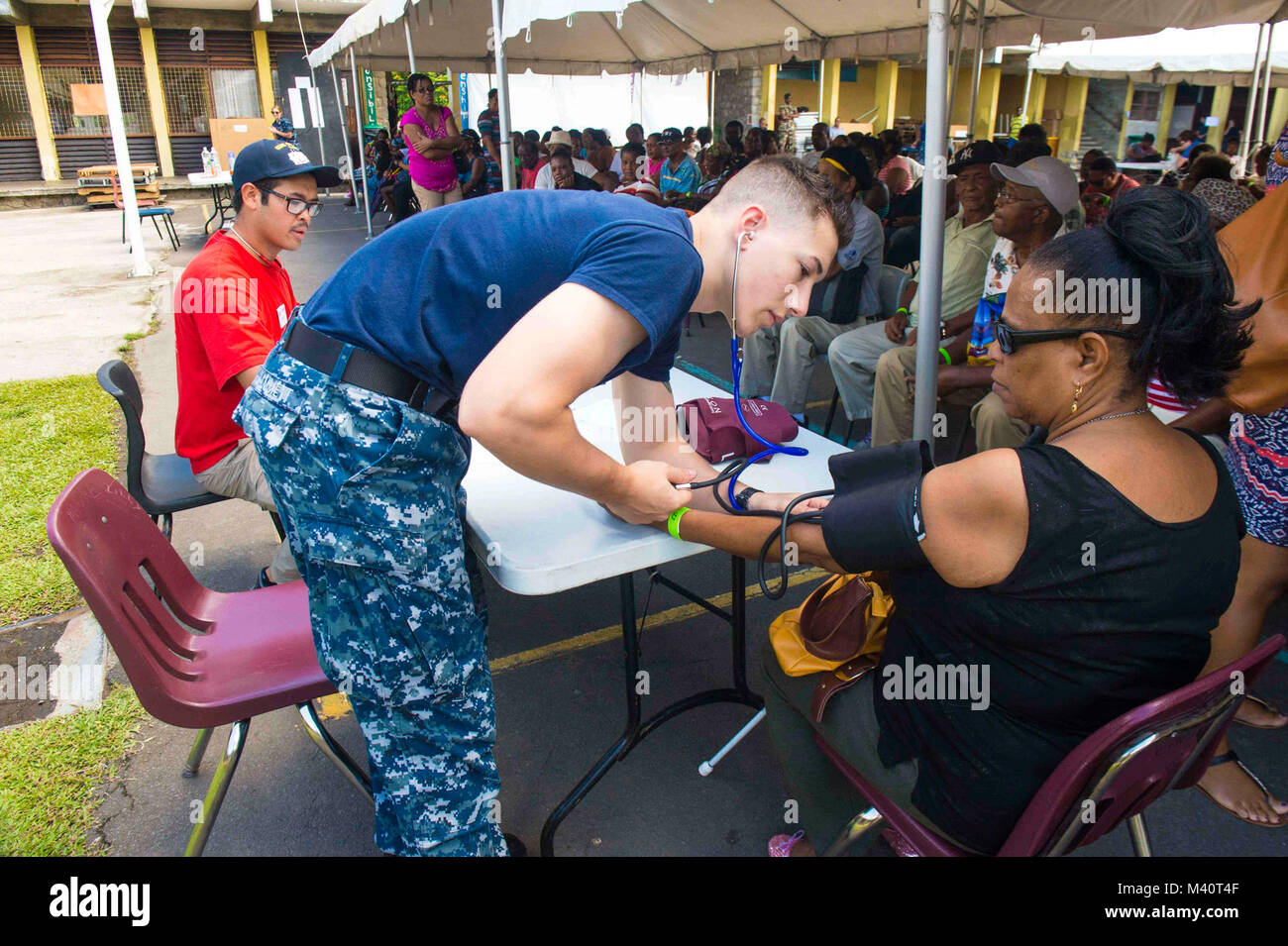 150801-N-YM856-107 ROSEAU, Dominica (1 agosto 2015) Hospitalman Cody Hammett, nativo di Gladstone, Virginia, assegnato a al Centro Medico Navale di Portsmouth, Va., prende la pressione sanguigna di un paziente a un sito medico istituito presso la Dominica Grammar School durante continuando promessa 2015. Continuando la promessa è un U.S. Comando sud-sponsorizzato e U.S. Forze Navali Comando meridionale/STATI UNITI 4a flotta-condotto di distribuzione condotta civile-militare comprendente le operazioni di aiuto umanitario assistenza civile, esperto in materia di scambi, medico, dentista, veterinario e il supporto tecnico e di risposta ai disastri t Foto Stock