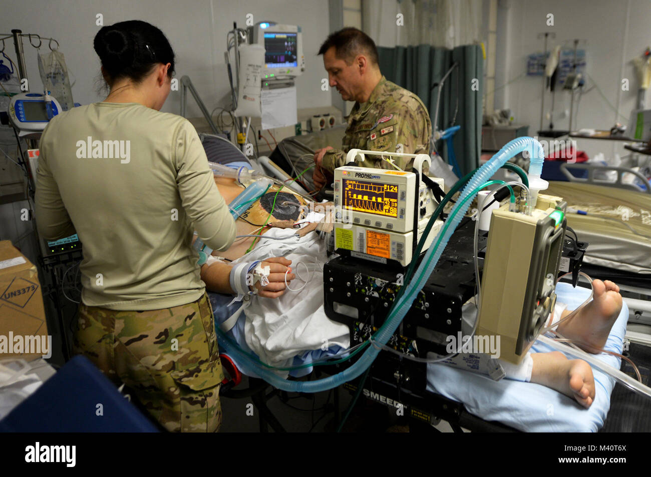 Il cap. Suzanne Morris e il Mag. Michael Mackovich, 455th Expeditionary evacuazione di medicina aeronautica Squadron Critical Care il trasporto aereo Team infermieri, collegare un paziente a CCATT attrezzature mediche a Bagram Airfield, Afghanistan. Un CCATT equipaggio costituito da un Medico, cura intensiva infermiere e un fisioterapista respiratorio, rendendo possibile spostare gravemente feriti o gravemente malati servicemembers dall'aria. (U.S. Air Force foto/Senior Airman Chris Willis) Dopo la battaglia-006 da AirmanMagazine Foto Stock