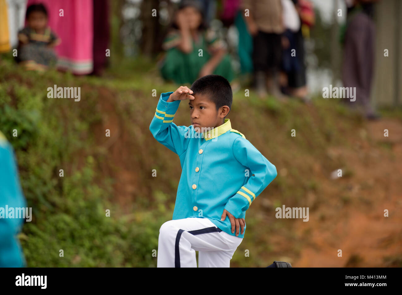 Un giovane ragazzo Ngäbe-Bugle saluta durante una marching band parade di Panama Ngäbe-Bugle della comarca. Foto Stock