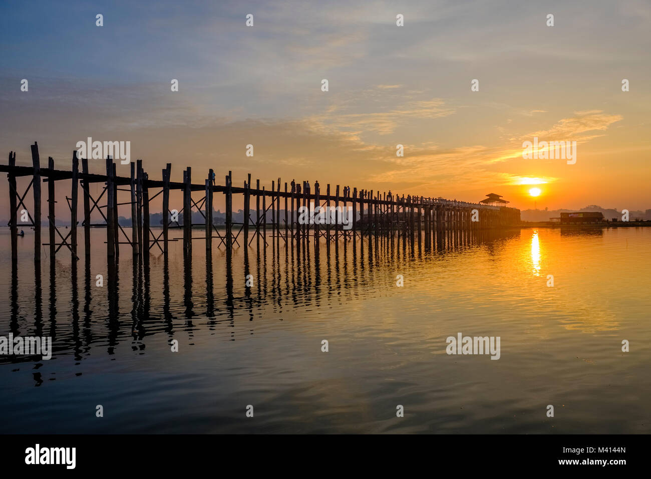 U Bein Bridge, un vecchio ponte di legno di teak, mirroring è sul Lago Taungthaman presso sunrise Foto Stock