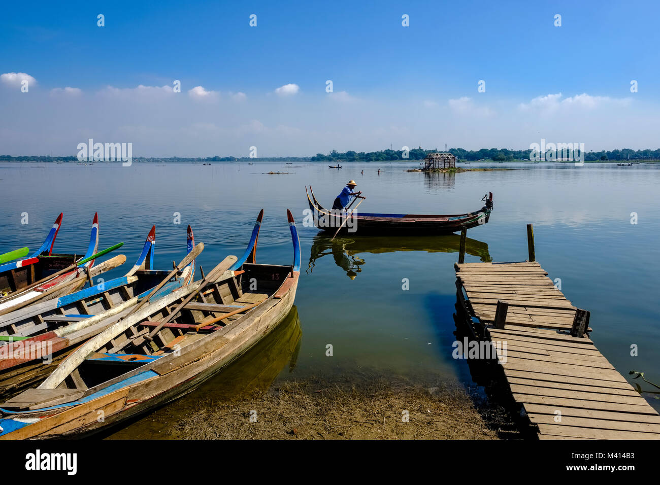 Le barche a remi sono serrati fino al Lago Taungthaman, accanto a U Bein Bridge Foto Stock