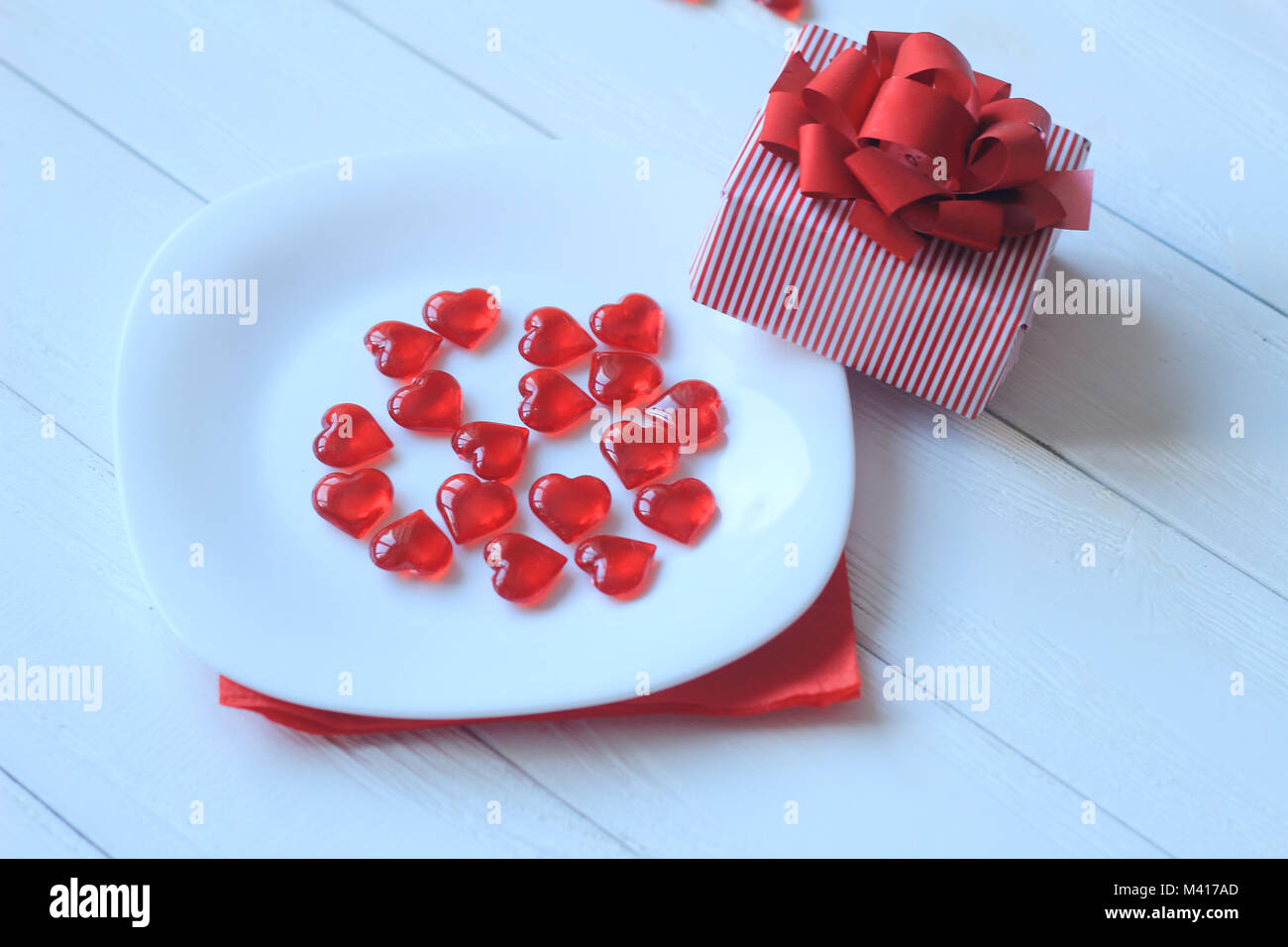 Close up.cuori rossi sulla piastra bianca e confezione regalo su sfondo chiaro Foto Stock