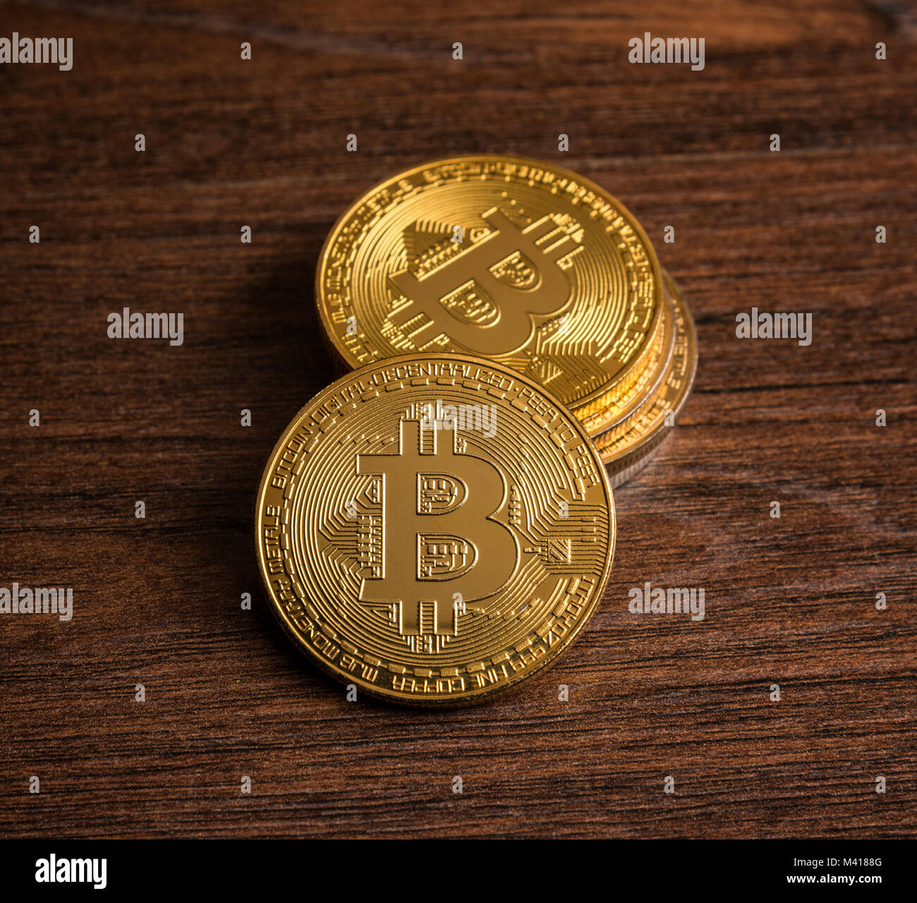 Pila di golden bitcoins scuro sul tavolo di legno Foto Stock