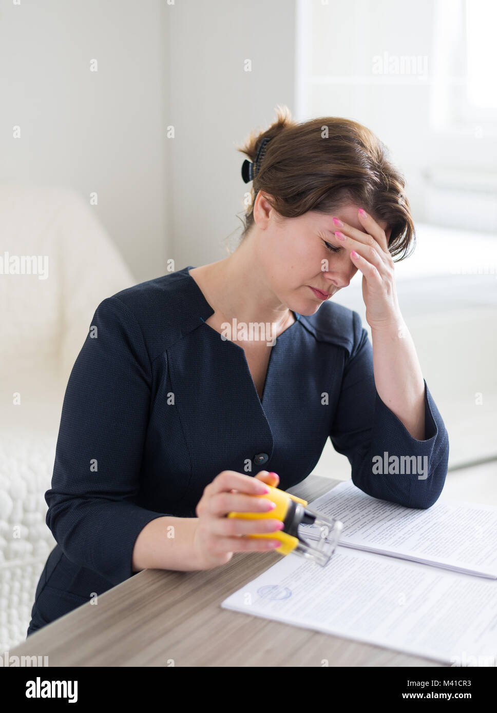 Una donna contabile che lavora con un mal di testa Foto Stock