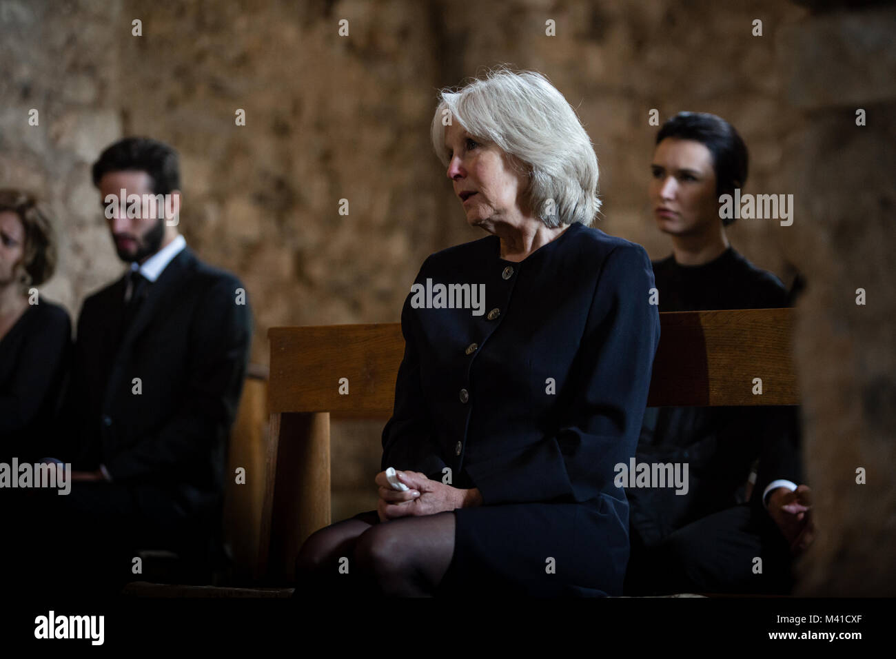 Senior donna con la famiglia al funerale Foto Stock