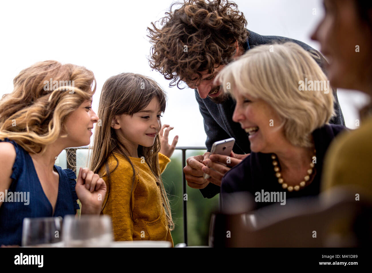 Generazioni di famiglia tutti guardando insieme allo smartphone Foto Stock