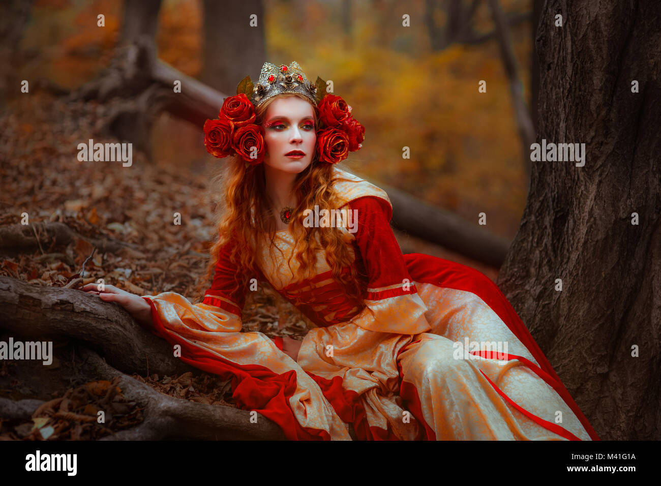 Una giovane donna in rosso vestito medievale passeggiate nel paese delle meraviglie Foto Stock