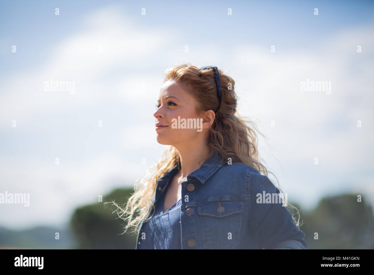 Giovane femmina adulta guardando il cielo blu Foto Stock