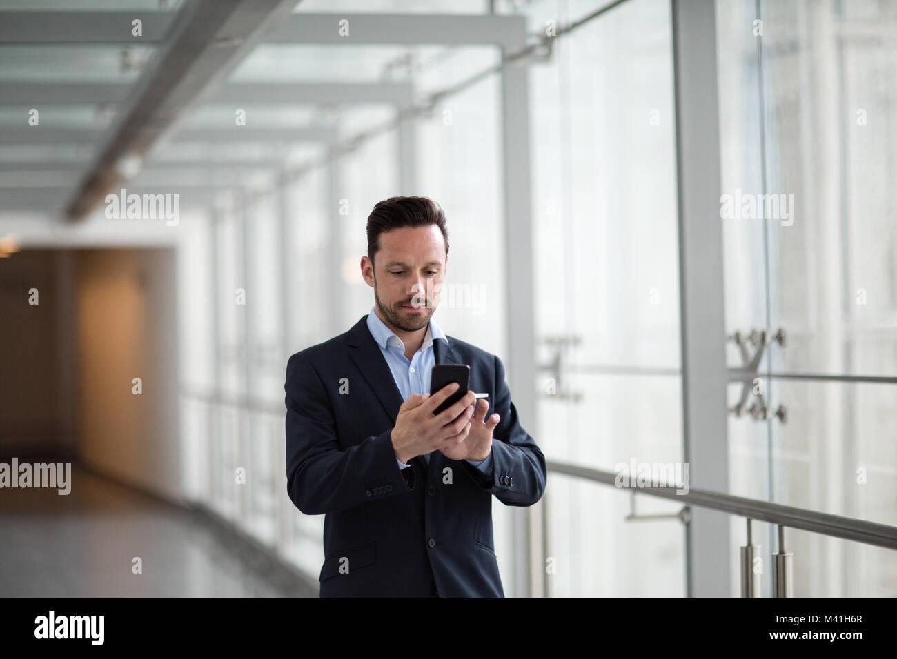 Imprenditore utilizza lo smartphone app sul suo tragitto Foto Stock