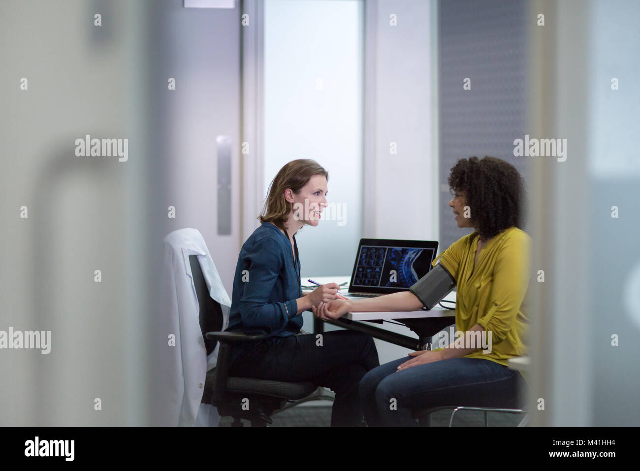 Donne medico tenendo a pazienti con pressione sanguigna Foto Stock