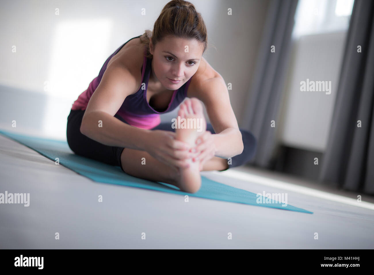 Giovane femmina adulta stretching Foto Stock