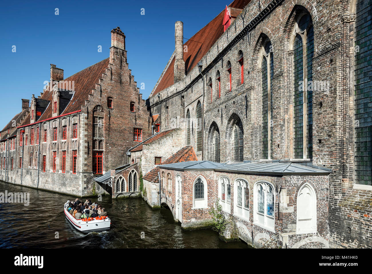 Il Museo di Archeologia (sinistra), Ospedale Museum (a destra), e le persone in barca nei canali di Bruges, Belgio Foto Stock