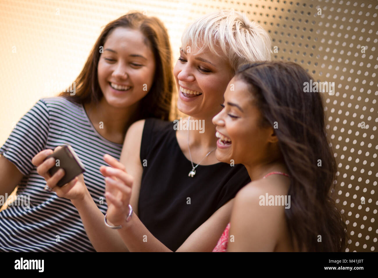 Amici di sesso femminile guardando smartphone Foto Stock