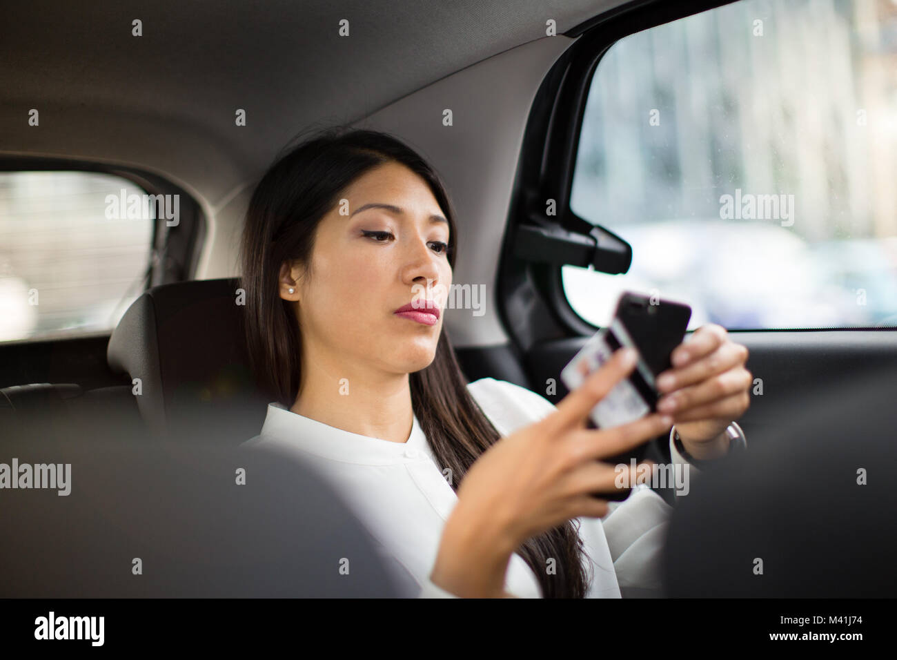 Imprenditrice di pagare tramite app per taxi ride Foto Stock