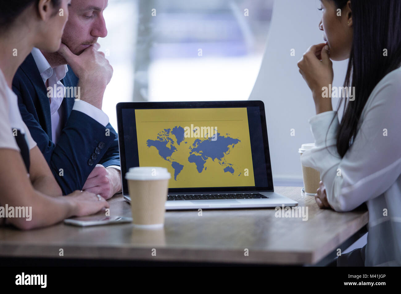 I colleghi guardando una presentazione sul computer portatile Foto Stock