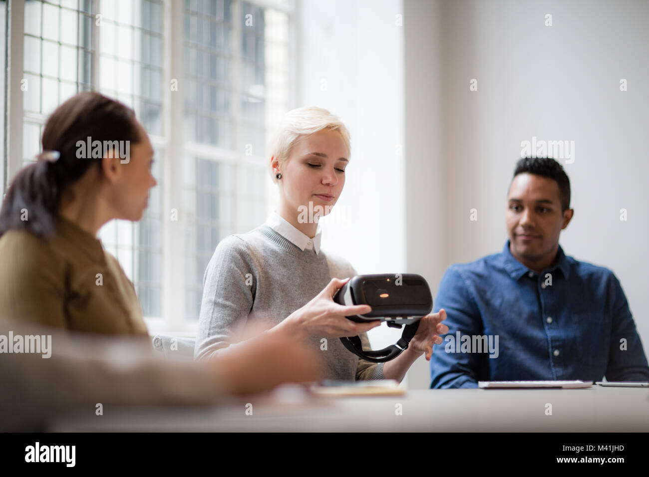 Designer presentando la realtà virtuale auricolare in una riunione Foto Stock