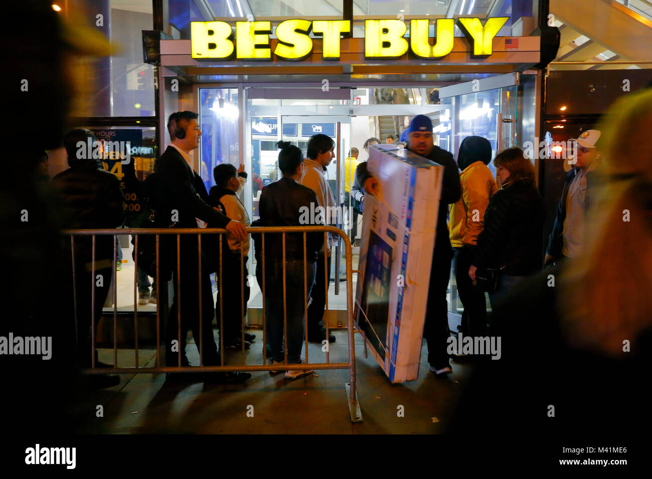 Un acquirente esce da un Best Buy con un grande schermo TV durante l'evento di shopping del Black Friday a New York City. Foto Stock