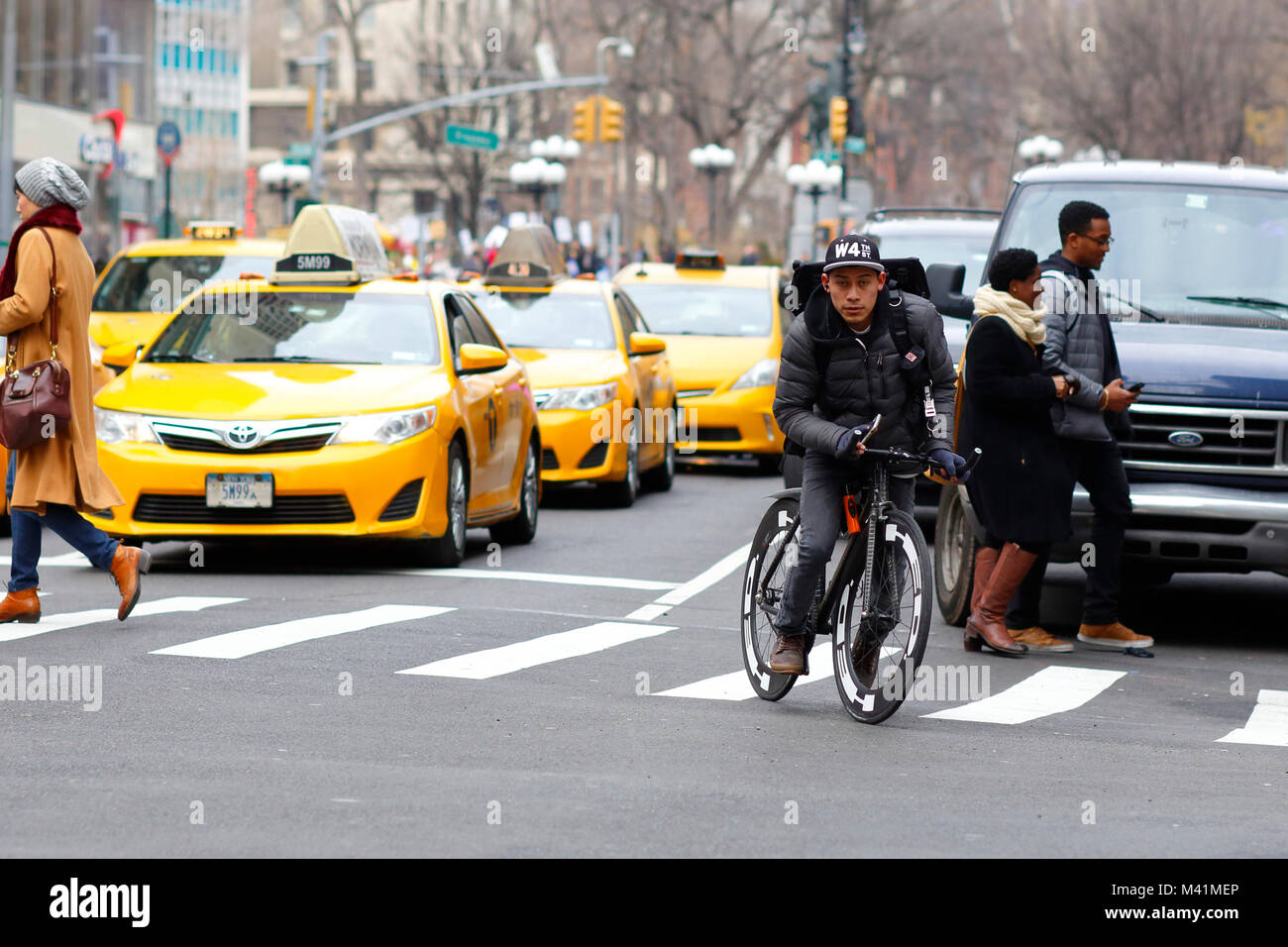 Un messaggero in bicicletta di new york per le strade di Manhattan con taxi gialli sullo sfondo. Gennaio 17, 2018 Foto Stock