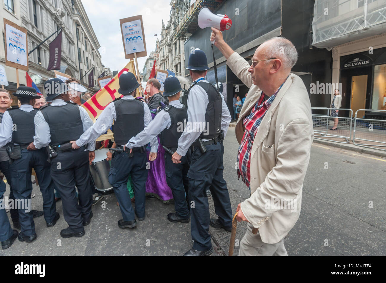 Ian osso della guerra di classe può contenere fino un megafono su impostazione sirena della polizia come spingere con forza i manifestanti in tutta la strada da dove si desidera protestare presso Sotheby's contro il licenziamento di 4 lavoratori. Foto Stock