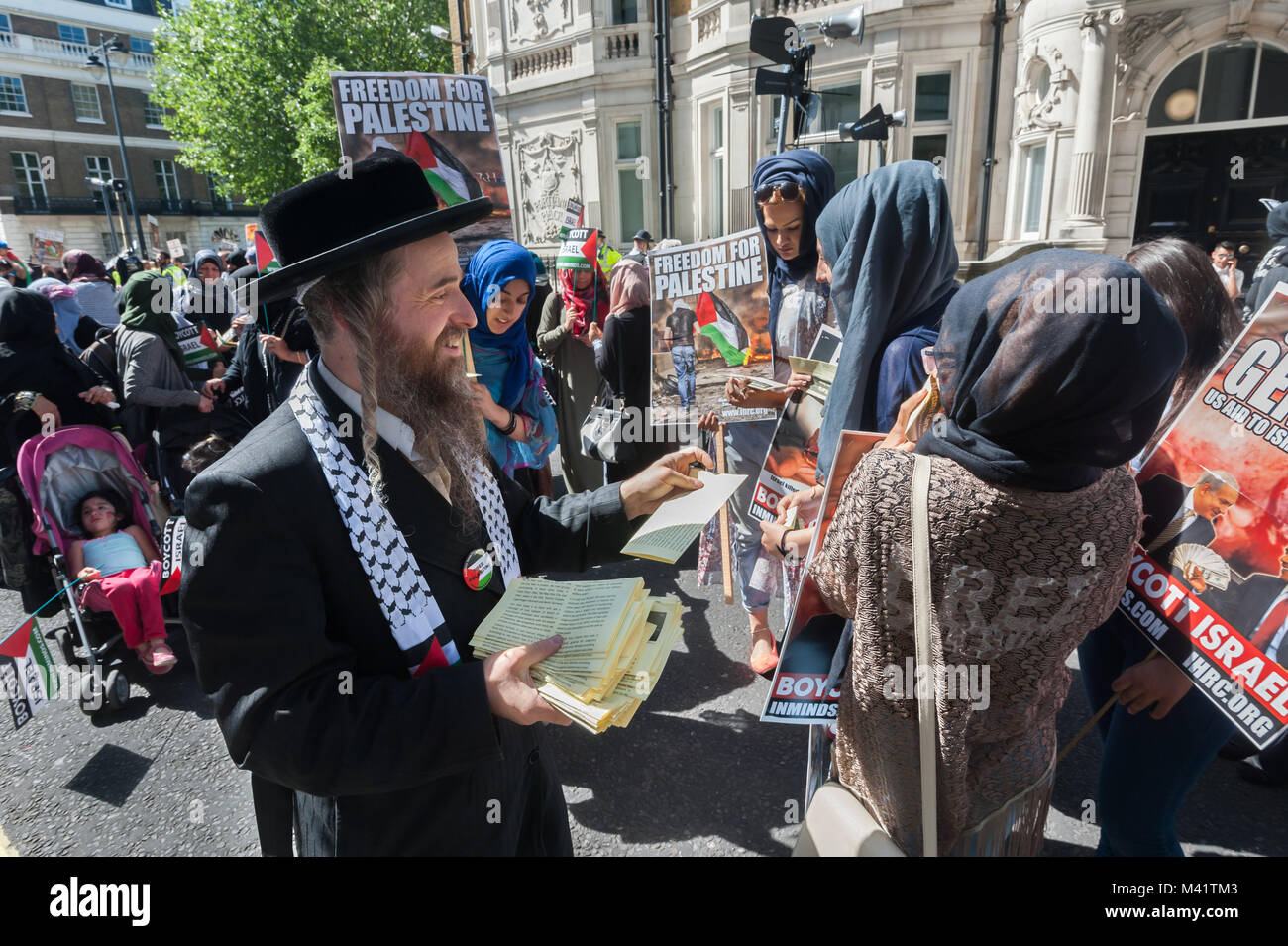 Un anti-sionista Neturei Karta ebreo mani volantini circa le loro credenze di dimostranti sul Al Quds giorno marzo a Londra. Foto Stock