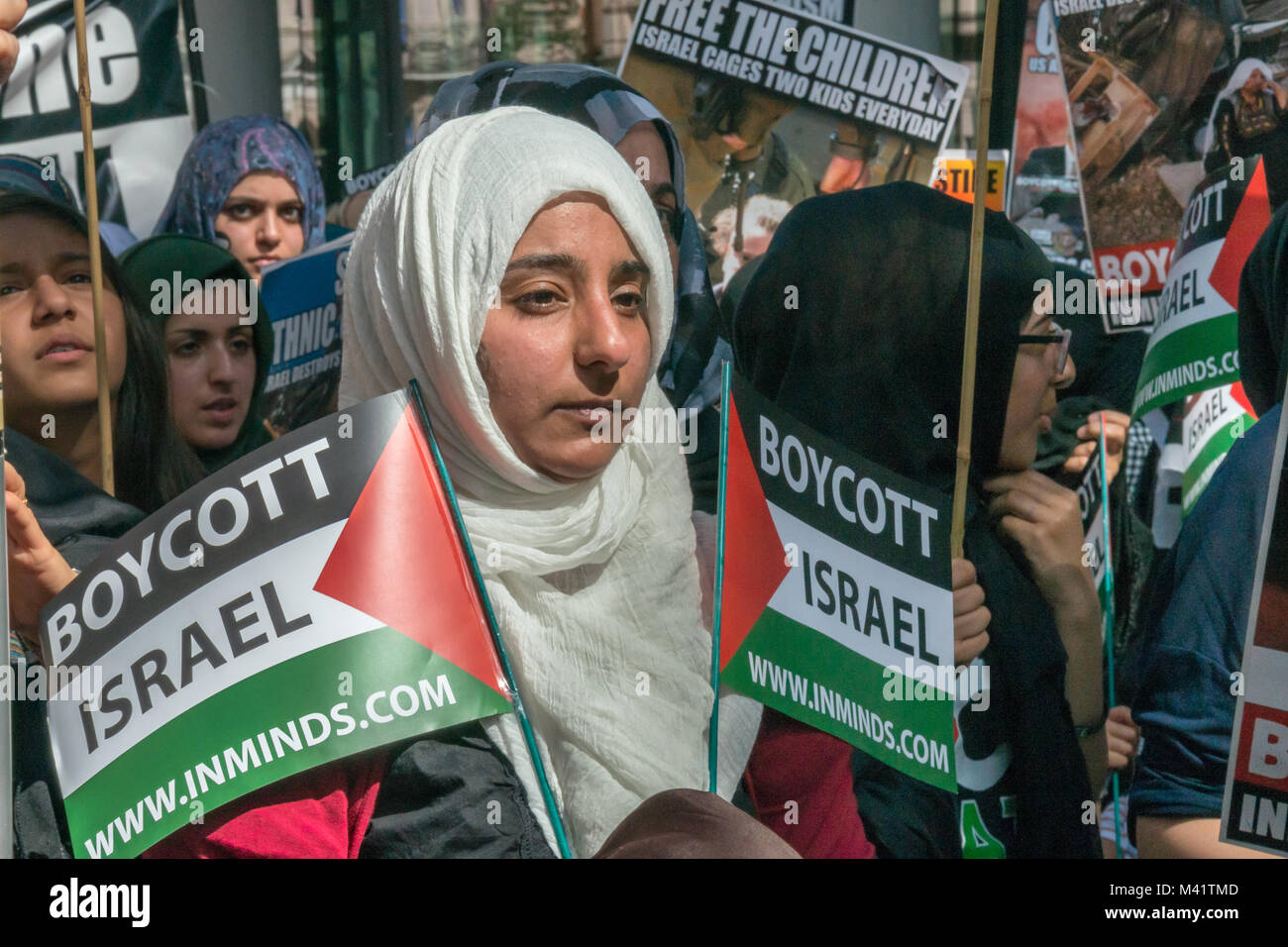 Una donna in grado di contenere due "Boicottare Israele" bandiere palestinese come ella attende all'inizio di Al Quds giorno marzo a Londra. Foto Stock