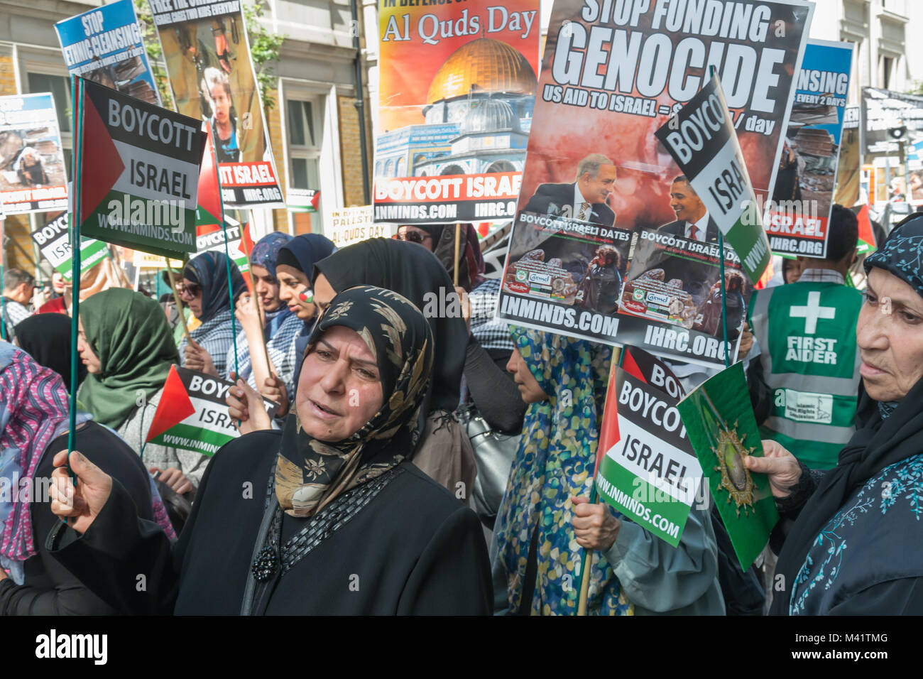 Le donne con cartelli circa il genocidio israeliano e il boicottaggio nei confronti di Israele all'inizio di Al Quds giorno marzo a Londra. Foto Stock